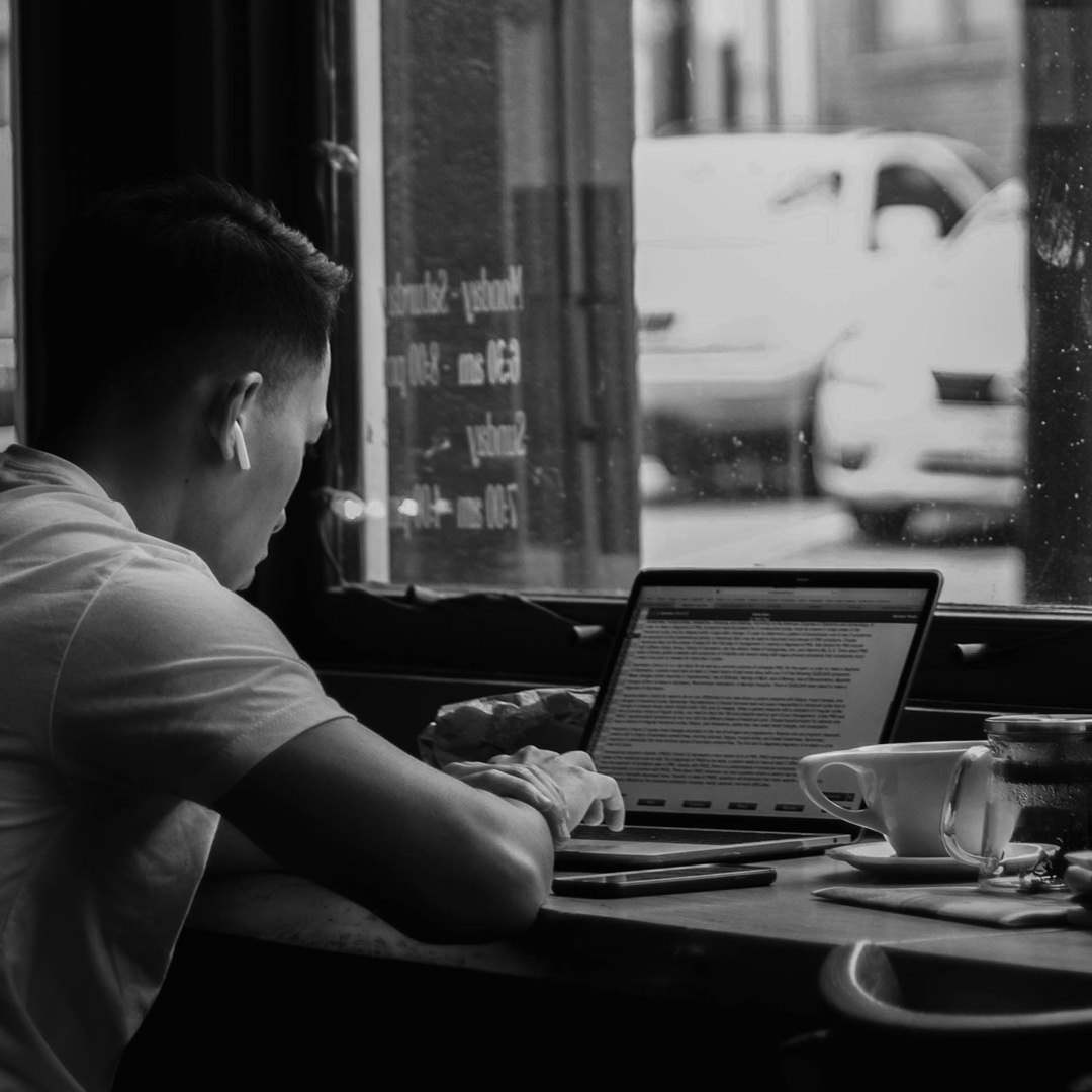 man sitting in cafe on laptop